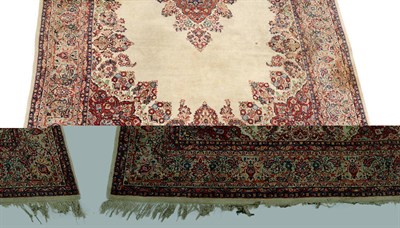 Lot 1382 - A Sarouk Carpet, the open ivory field centred by a red floral medallion within red spandrels,...