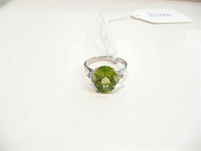 Lot 186 - An 18 carat white gold peridot and diamond cluster ring