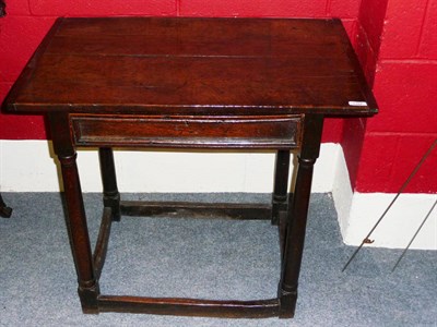 Lot 1392 - A 17th Century Oak and Elm Joined Table, the boarded top with cleated ends over a frieze drawer, on