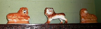 Lot 345 - Three Staffordshire pottery lions