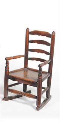 Lot 1411 - A 19th Century Child's Turned Ash Ladder Back Rocking Chair, the slatted back and boarded seat...