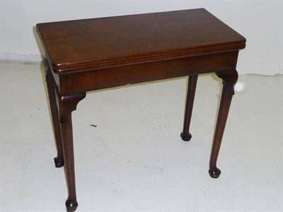 Lot 1421 - A George III Mahogany Foldover Tea Table, the slightly rounded rectangular top above a plain...