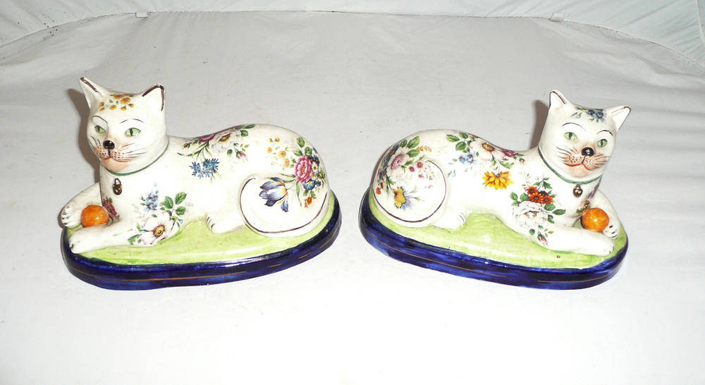 Lot 8 - Pair of Staffordshire tin glazed figures of recumbent cats