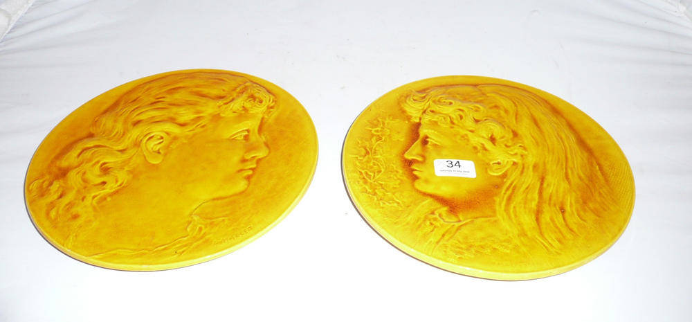 Lot 34 - Pair of Burmantofts circular plaques, mustard glaze with impressed factory marks '1010' and '1011'