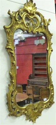 Lot 1458 - A George III Giltwood Wall Mirror, the shaped rectangular plate within a leaf carved scrolling...