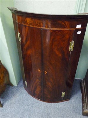 Lot 1461 - A George III Mahogany Corner Cupboard, the stepped and projecting cornice above a plain frieze with