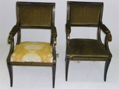 Lot 1467 - A Pair of Regency-Style Black and Gold-Painted Elbow Chairs, the scrolled backs with an upholstered