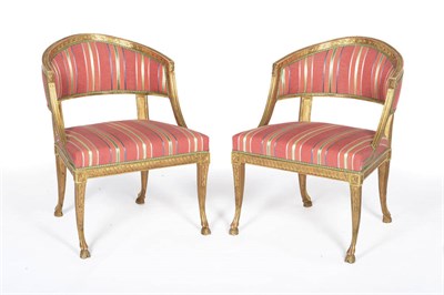 Lot 1472 - A Pair of Swedish Gilt Painted Tub Chairs, 19th century, upholstered in multi-coloured striped...