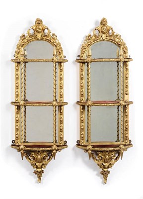 Lot 1498 - A Pair of Giltwood and Gesso Wall Mirrors, mid 19th century, the oval plates within leaf carved and