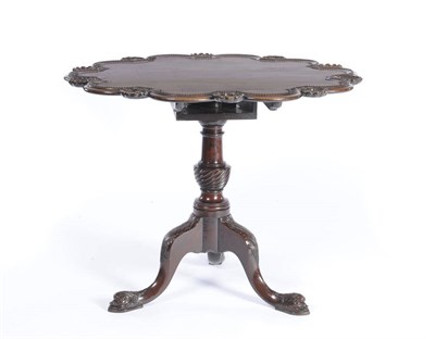 Lot 1617 - A Mahogany Tilt-Top Table probably 18th Century, the shaped top with a moulded and beaded edge...