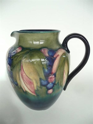 Lot 1626 - A William Moorcroft "Leaf & Grape" Jug, on a blue/green wash ground, painted blue monogram,...