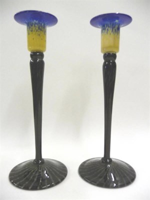 Lot 1672 - A Pair of Schneider Glass Candlesticks, the blue and cream sconces on tapering black, purple...