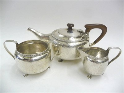 Lot 1676 - An Arts & Crafts Three Piece Teaset, by A Edward Jones, Birmingham 1919, comprising teapot with...