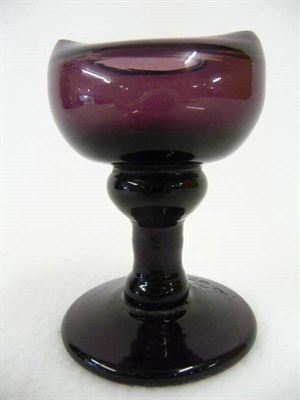 Lot 37 - An Amethyst Glass Pedestal Eye Bath, early 19th century, the boat shape bath on an inverted...