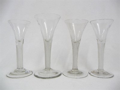 Lot 45 - A Group of Four Wine Glasses, circa 1750, each with one piece drawn trumpet bowls, the stems...