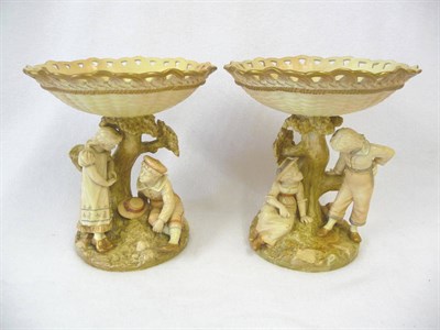 Lot 81 - A Pair of Hadleys Worcester Porcelain Figural Dessert Basket, 1890, each modelled as a young...