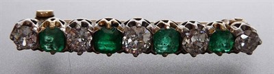 Lot 220 - An Emerald and Diamond Line Brooch, the alternating calibré cut emeralds and round brilliant...