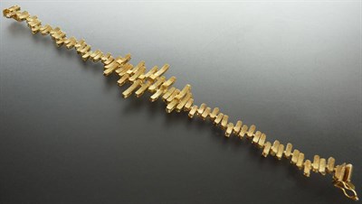 Lot 238 - A Textured Link Bracelet, tube links of yellow metal lozenge form are arranged asymmetrically,...