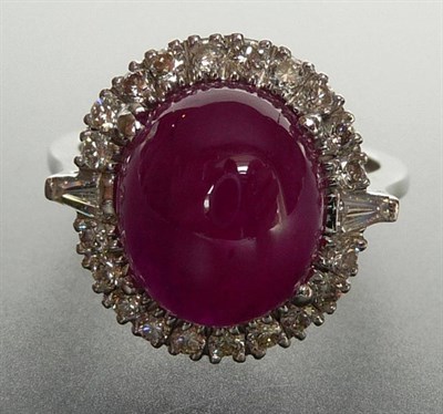 Lot 240 - A 14 Carat White Gold Ruby and Diamond Cluster Ring, a cabochon ruby held in a four claw...