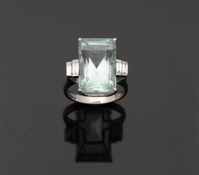 Lot 249 - An 18 Carat White Gold Aquamarine and Diamond Ring, the baguette cut aquamarine sits between...