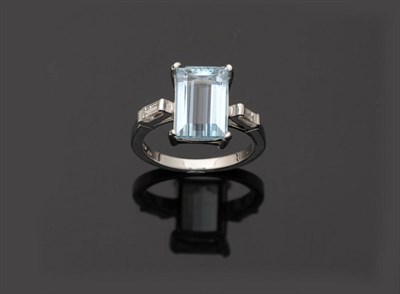 Lot 251 - An 18 Carat White Gold Aquamarine and Diamond Three Stone Ring, the baguette cut aquamarine in...