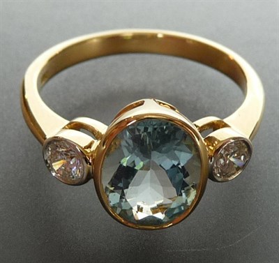 Lot 261 - An Aquamarine and Diamond Three Stone Ring, the oval cut aquamarine sits between two round...