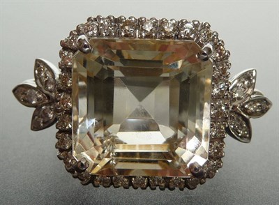 Lot 274 - An 18 Carat White Gold Citrine and Diamond Cluster Ring, the trap cut citrine in a four claw...