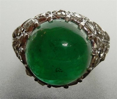 Lot 289 - An Emerald and Diamond Cocktail Ring, a cabochon emerald held in a white claw setting above a...