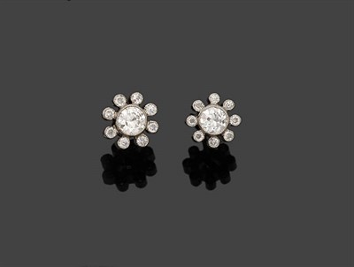 Lot 323 - A Pair of Diamond Cluster Stud Earrings, a principal round brilliant cut diamond in a spaced border