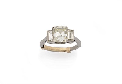 Lot 338 - A Diamond Three Stone Ring, the central emerald-cut diamond in a white four claw setting sits...