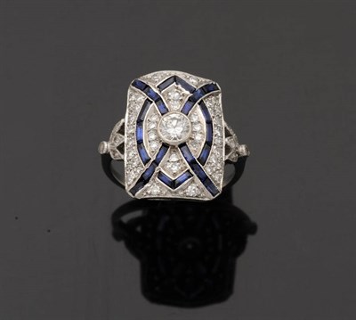 Lot 343 - An Art Deco Style Sapphire and Diamond Cluster Ring, a central round brilliant cut diamond sits...