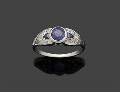 Lot 354 - A Sapphire and Diamond Ring, a round brilliant cut sapphire in a white rubover setting sits between