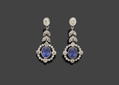 Lot 364 - A Pair of Sapphire and Diamond Drop Earrings, an oval cut sapphire within a diamond frame...