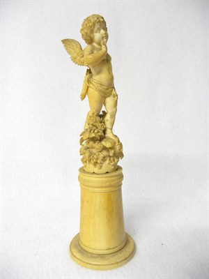 Lot 596 - A Carved Ivory Figure of Cupid, French, circa 1850, standing with loving forward gaze, wearing...