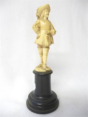 Lot 597 - A Carved Ivory Figure of a Standing Cavalier, French, circa 1850-70, wearing a broad rimmed feather