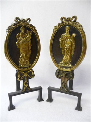 Lot 644 - A Pair of Brass Mounted Iron Andirons, circa 1900, each as a ribbon tied oval medallion...