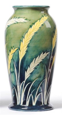 Lot 1033 - A William Moorcroft "Waving Corn" Vase, on a green/blue wash ground, painted blue signature,...