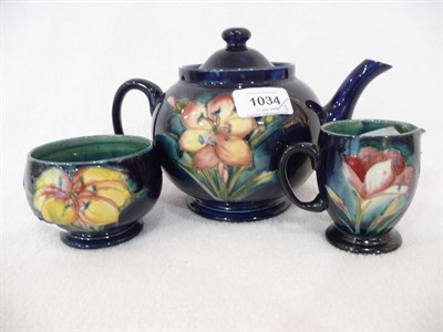 Lot 1034 - A Walter Moorcroft "Freesia" Tea Service, on a blue ground, comprising teapot and cover, milk...