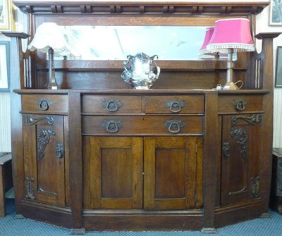 Lot 1130 - An Art & Crafts Oak Mirror Back Sideboard, shaped cornice over a bevel edged mirror above a...