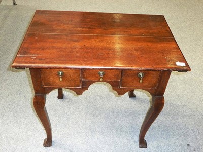 Lot 1148 - A George II Oak Dressing Table, the moulded top over three short drawers in a shaped frieze, on...