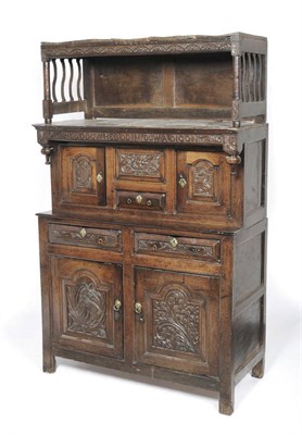 Lot 1150 - An 18th Century Oak Triddarn, the canopy with a leaf-carved frieze on turned supports with...