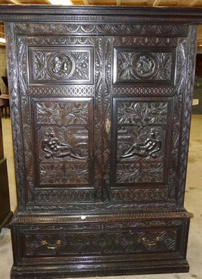 Lot 1155 - A Carved Oak Press Cupboard, the dentil and key pattern cornice above a lunette carved frieze...