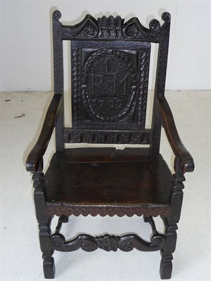 Lot 1159 - A Joined Oak Armchair, the scrolling top rail above a panel back with initials LRM, dated 1702, the