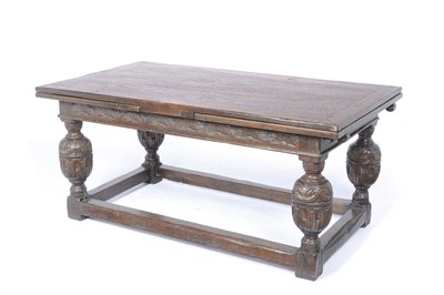 Lot 1165 - An Oak Drawleaf Refectory Dining Table, the rectangular cleated and boarded top above a carved...