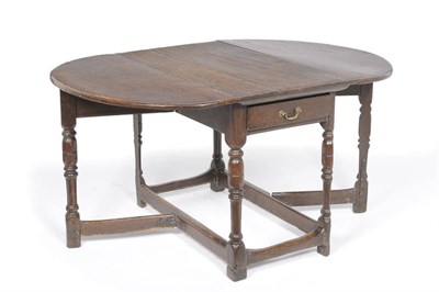 Lot 1169 - A Joined Oak Gateleg Table, the rectangular top with two D shaped drop leaves above a single frieze