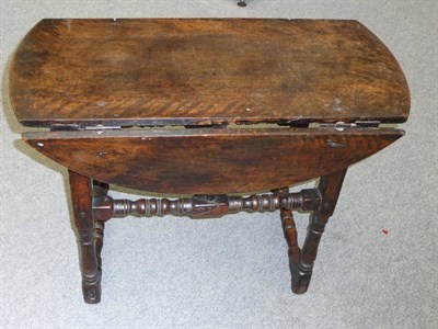 Lot 1185 - An 18th Century Continental Walnut Table, the oval top with hinged "butterfly" supports to...