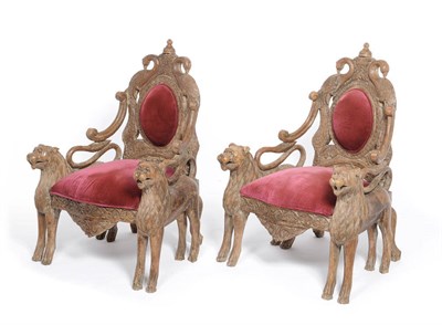 Lot 1190 - A Pair of Indian Teak Upholstered Elbow Chairs, the oval red velvet backs framed by carved...