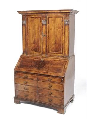 Lot 1192 - An 18th Century Continental Walnut Desk and Bookcase, having a coved cornice over two panelled...