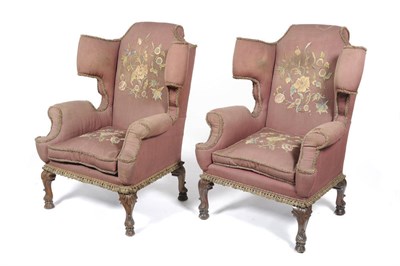 Lot 1226 - A Pair of Large Early Georgian-Style Wing Chairs, upholstered in dark red cloth overlaid with...