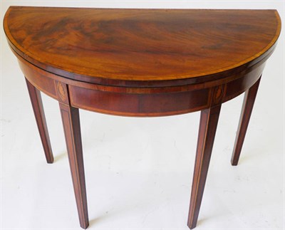 Lot 1251 - A George III Mahogany and Satinwood-Banded Card Table, the half-round top over a banded frieze,...